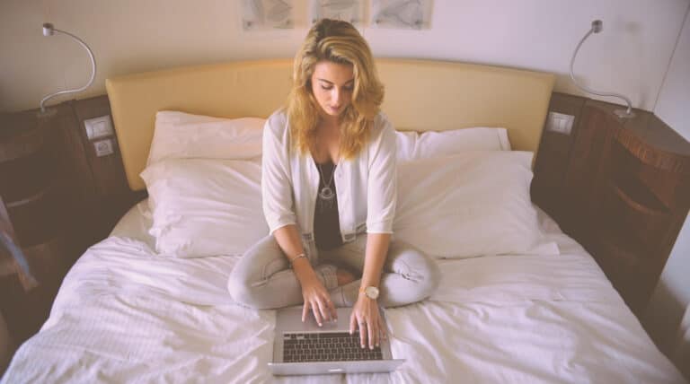 woman sitting on bed with laptop-starting an online business
