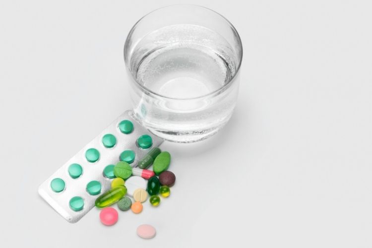glass of water and vitamins-how to get yourself to drink more water article