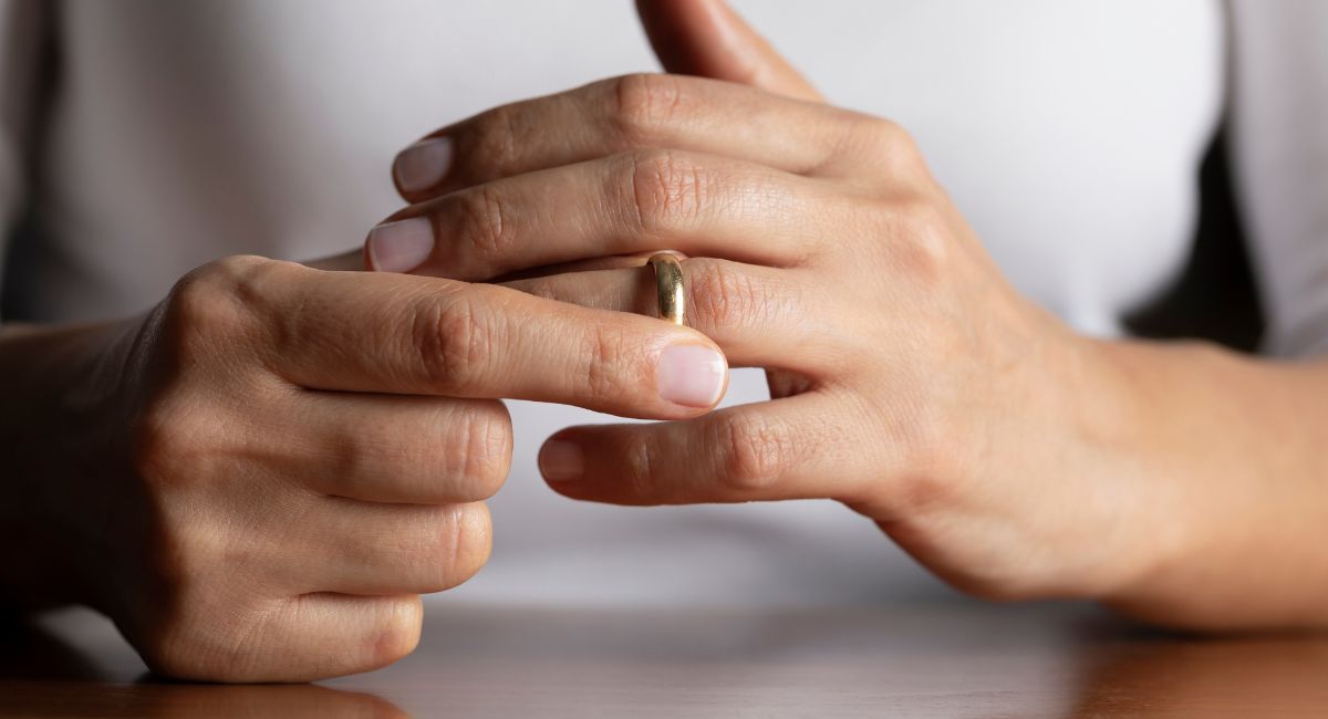 woman taking off wedding ring-how to get over a divorce after a long marriage