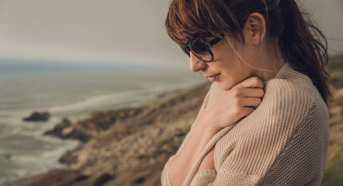 calming quotes - woman by lake hugging herself