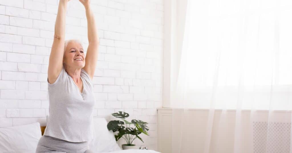 4 minute morning routine woman stretching in bed